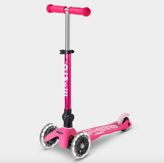 A pink Mini Micro foldable scooter with three wheels and adjustable handlebar, designed for children.